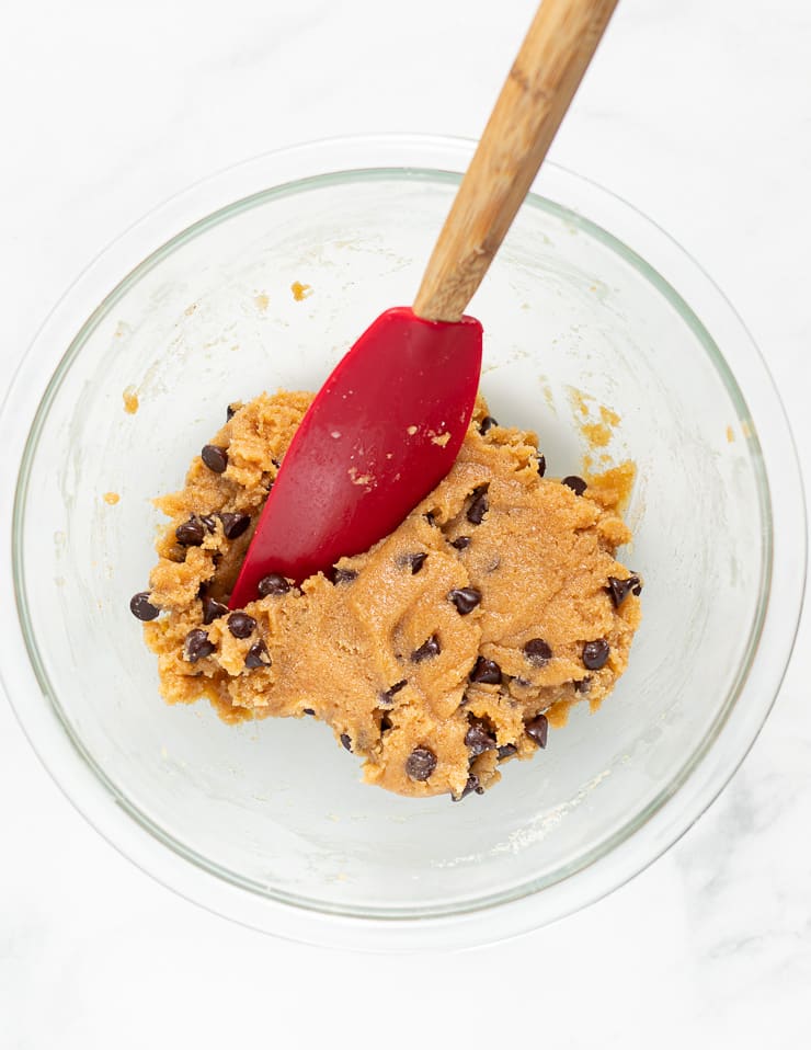 chocolate chip sbeing added to almond flour cookie dough