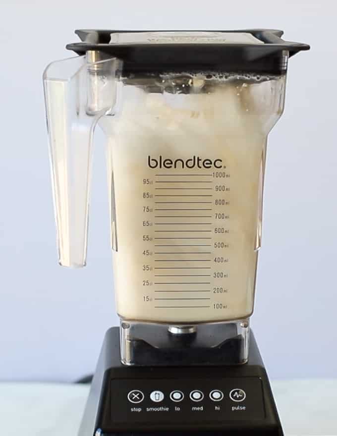 cashews and water being blended up in a blender