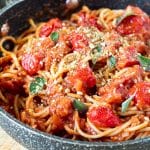Spaghetti tossed in cherry tomato sauce and topped with herbs and vegan brazil nut parm