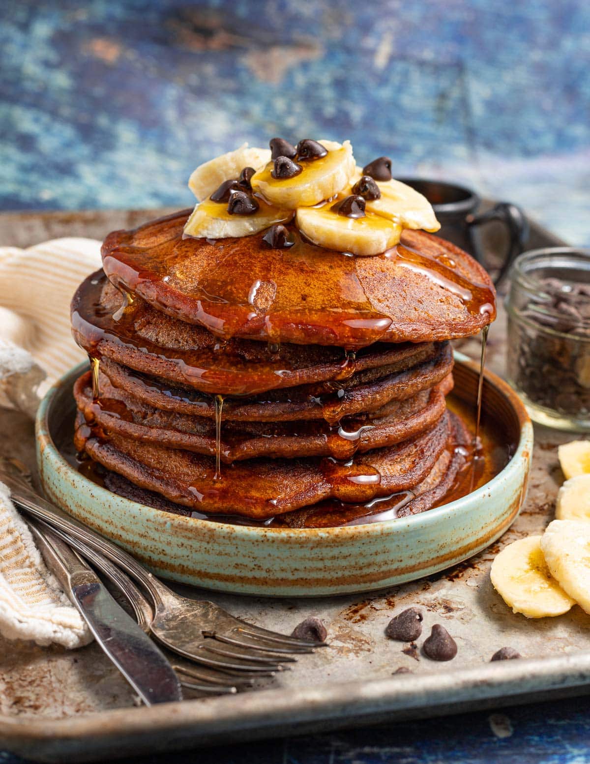 a stack of chocolate banana pancakes with maple syrup