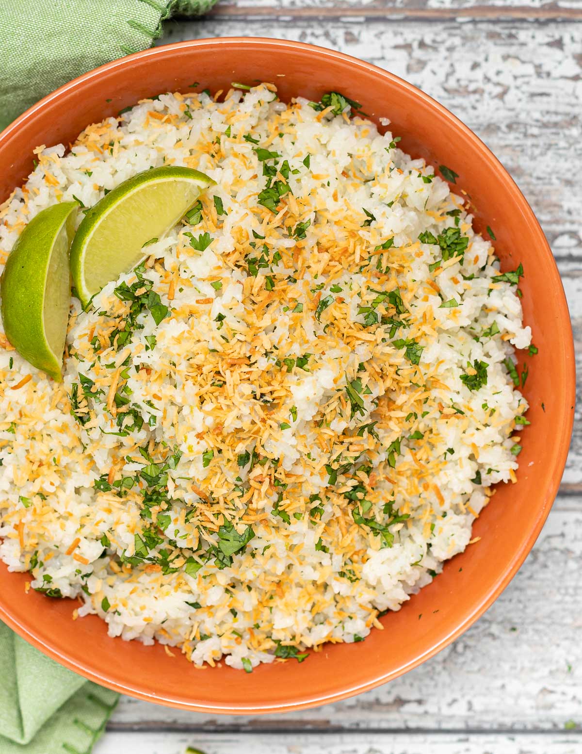 close up of coconut lime rice in a bowl with toasted coconut and cilantro