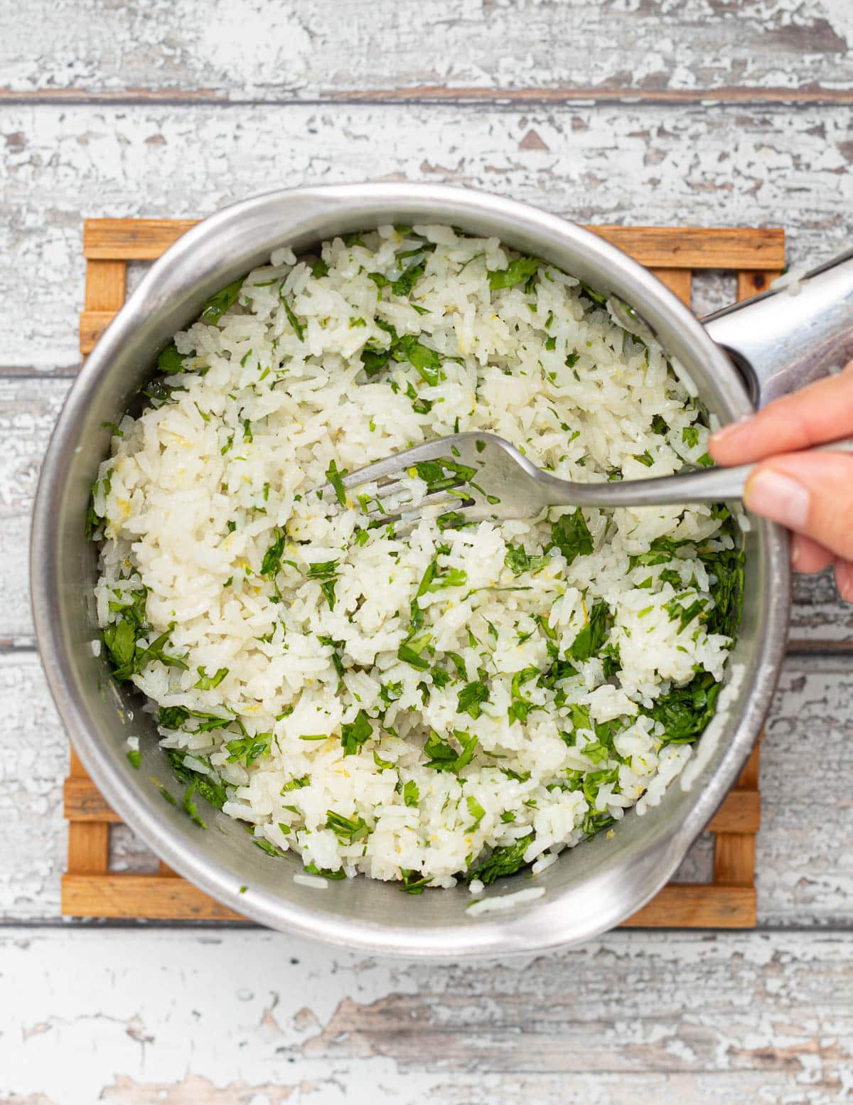 cilantro being stirred through a pan of rice