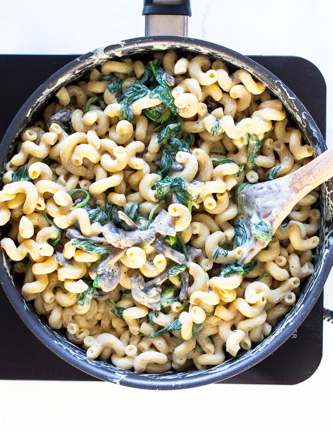 Creamy Vegan Mushroom Pasta in a pan with a wooden spoon