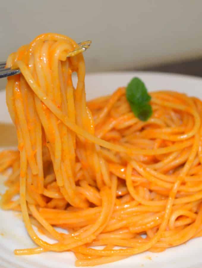 a plate of spaghetti coated in roasted pepper sauce