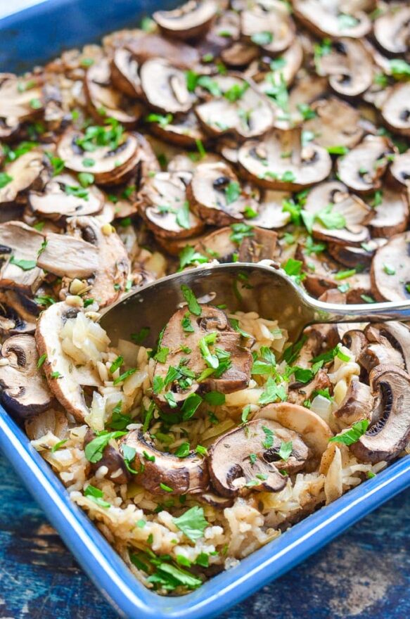 easy Oven Baked Garlic Mushroom Rice being served up with a spoon