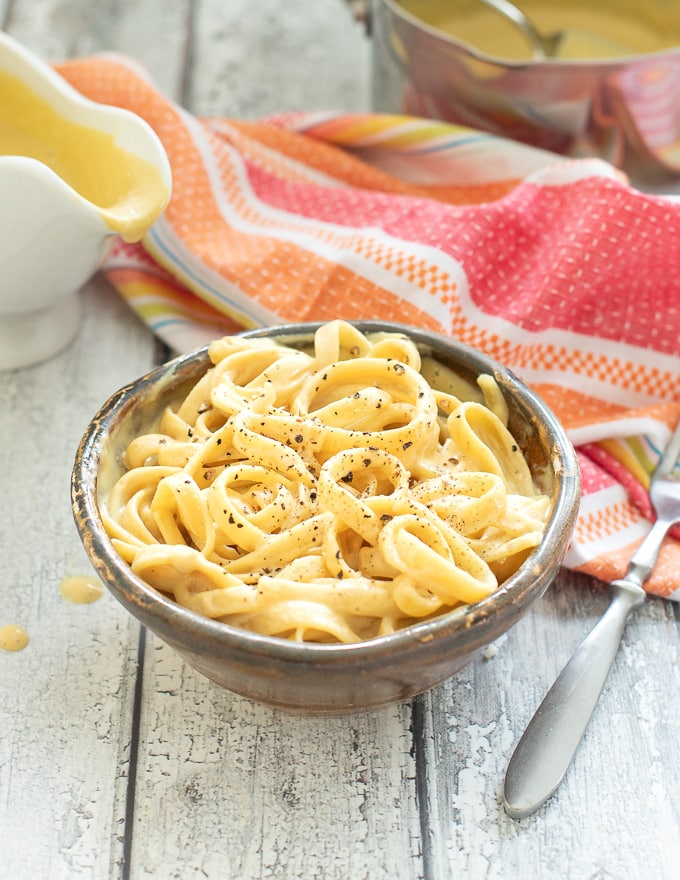 a bowl of vegan cheese sauce covered pasta