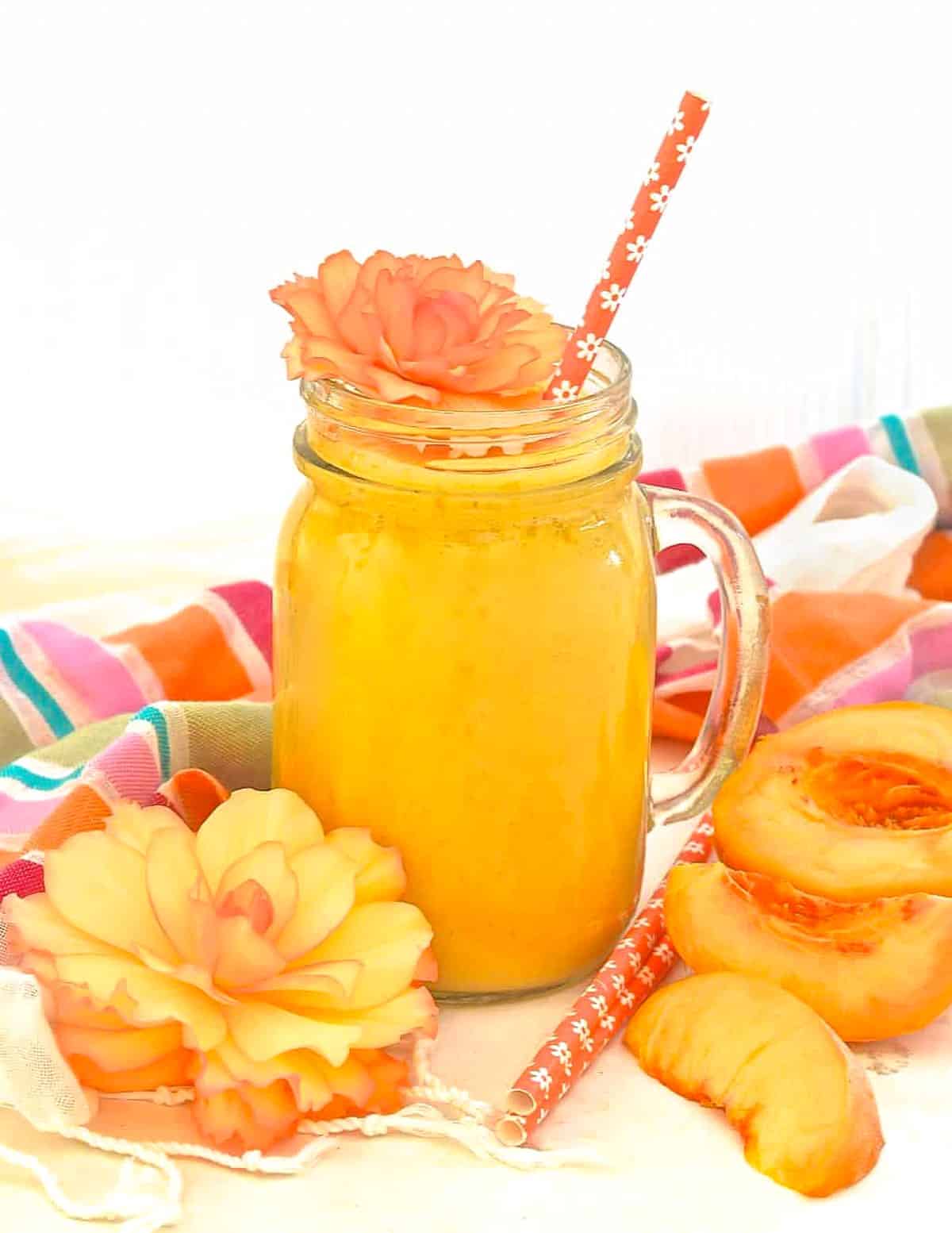 a peach smoothie with a straw
