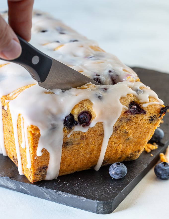 Gluten-free lemon cake with blueberries being cut