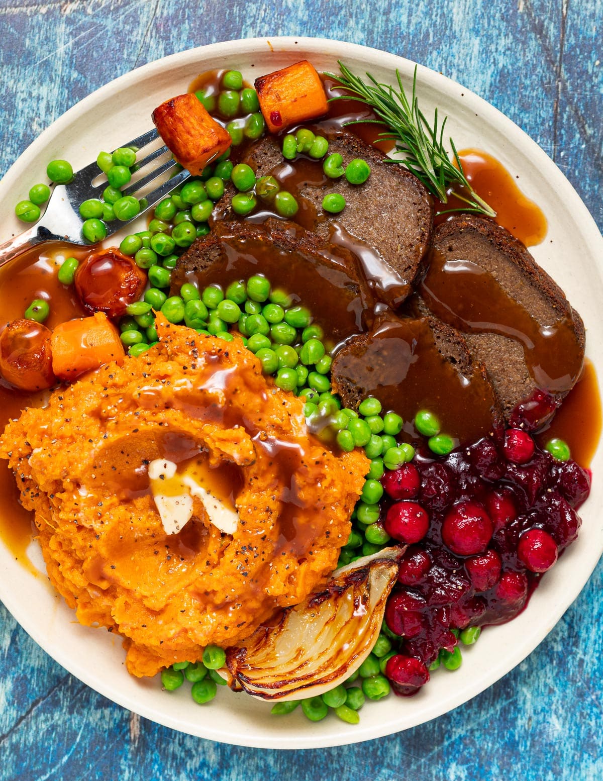a plate of gluten-free seitan, mashed sweet potato, gravy and vegetables