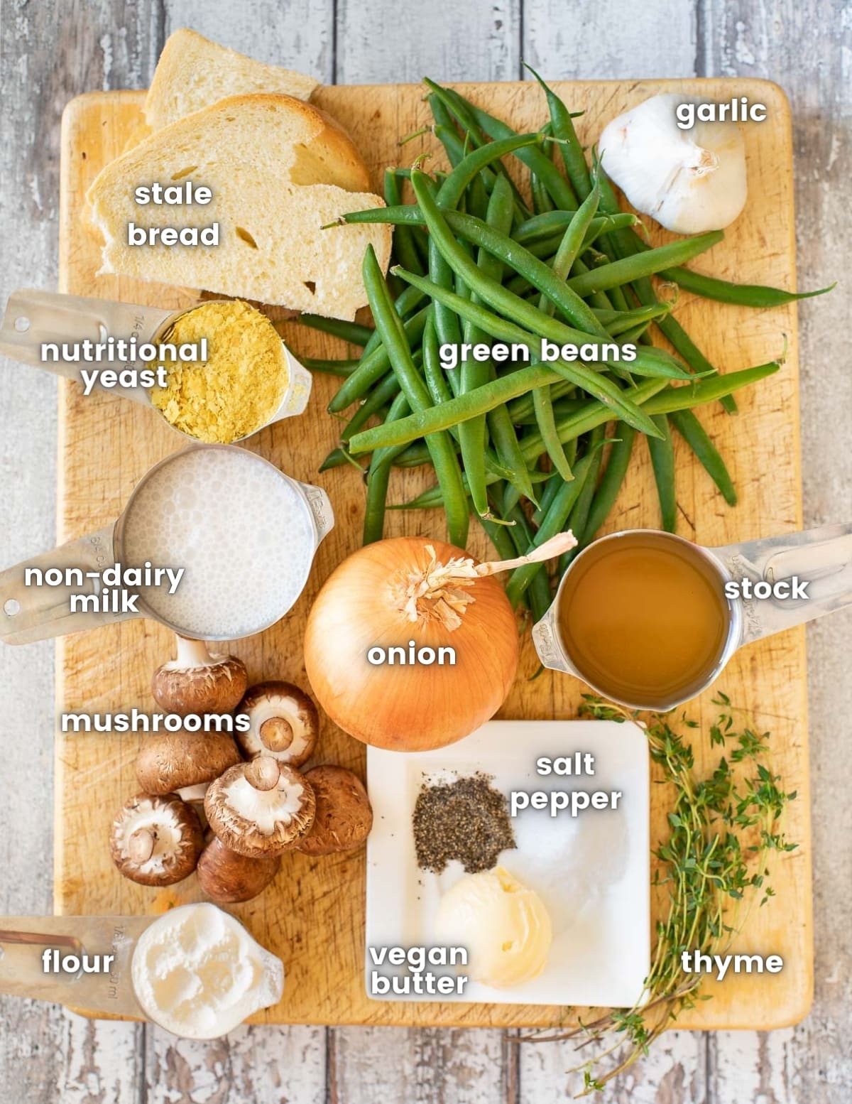 the ingredients for vegan green bean casserole on a wooden board