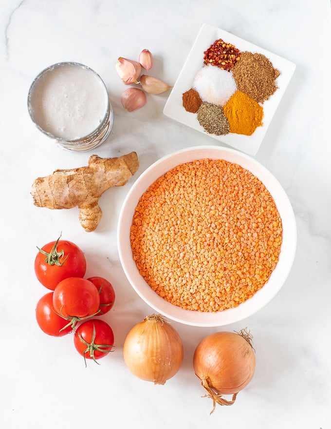 The ingredients for Instant Pot Lentil Dal laid out on a white marble surface