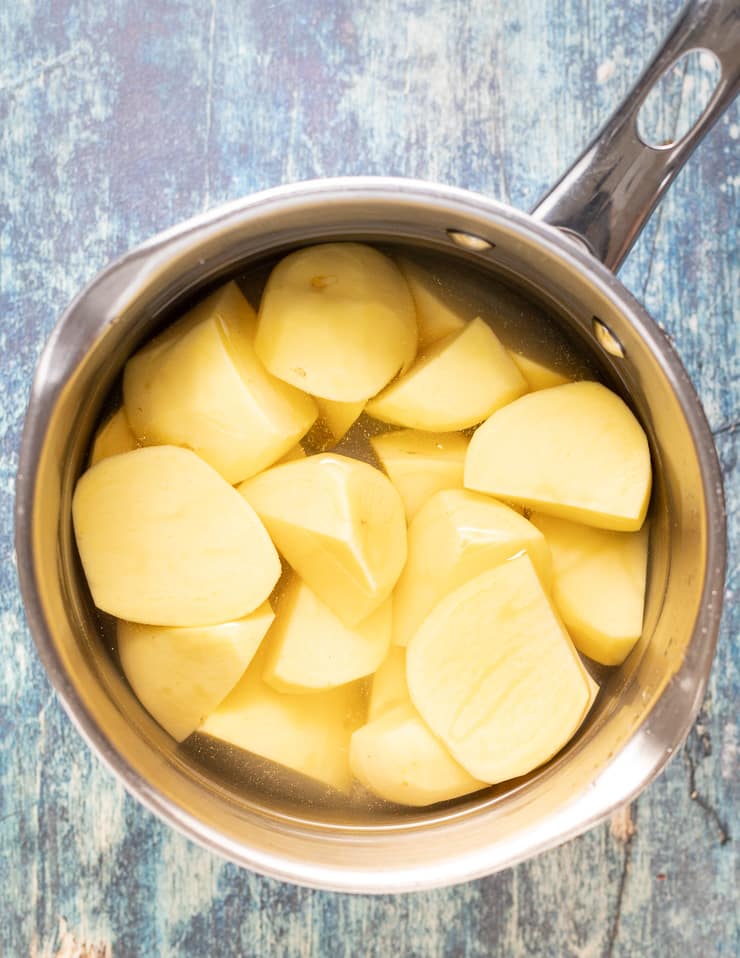 peeled and cut potatoes in a pan of water