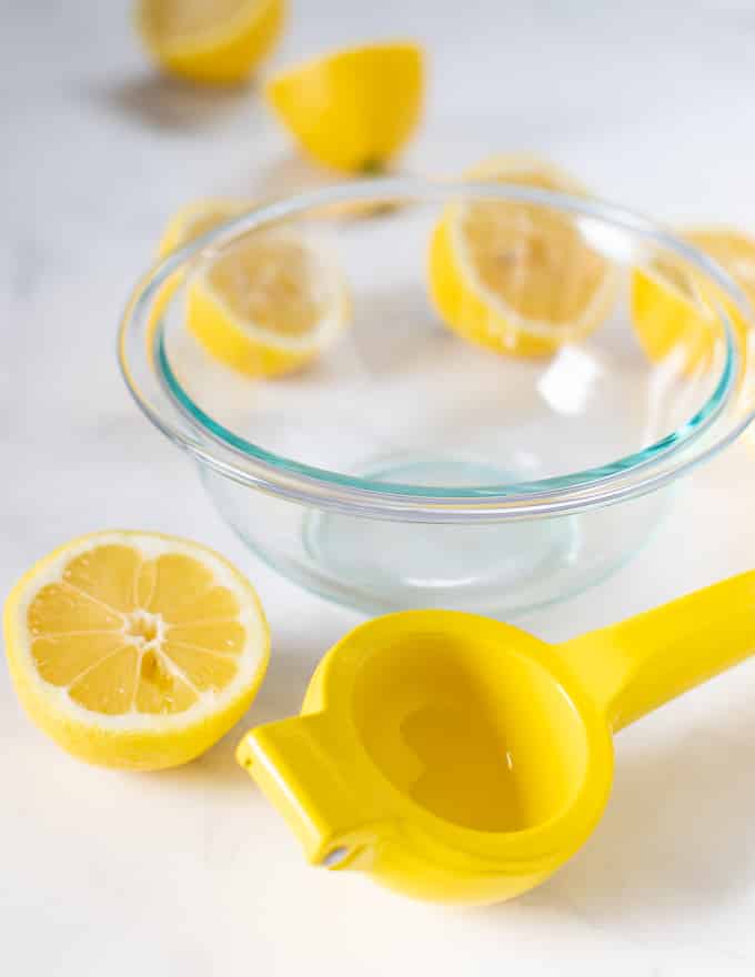 lemon juicer, bowl and lemon halves for making matcha lemonade