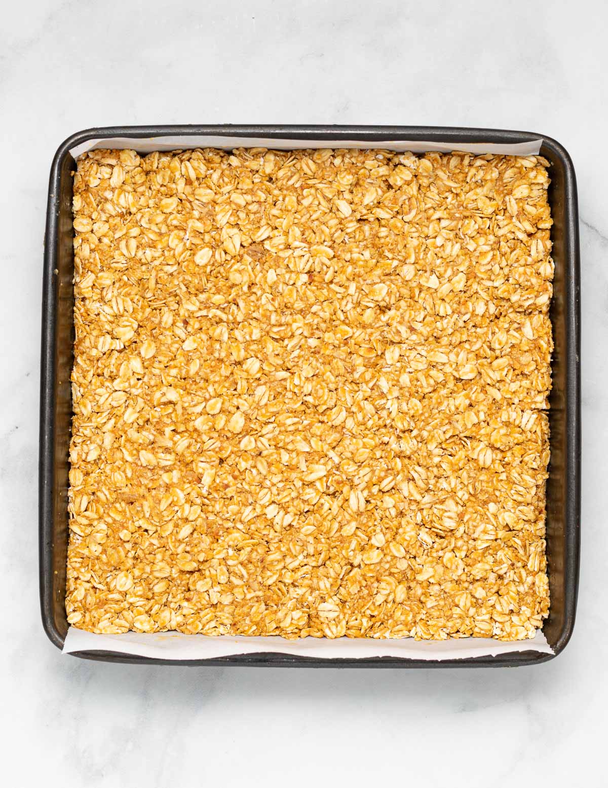 no bake oatmeal peanut butter bar mixture packed in a lined pan