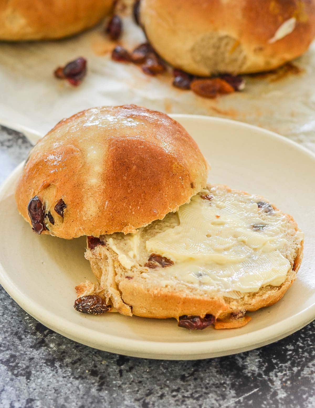 a cut hot cross bun spread with vegan butter