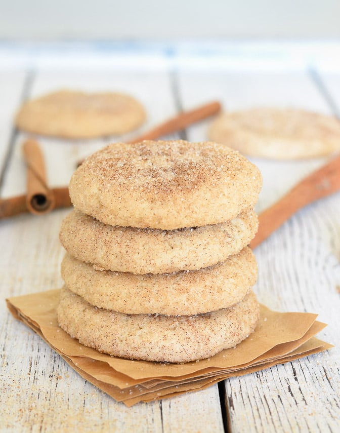 A stack of Perfect Vegan Snickerdoodles with cinnamon sticks in the background
