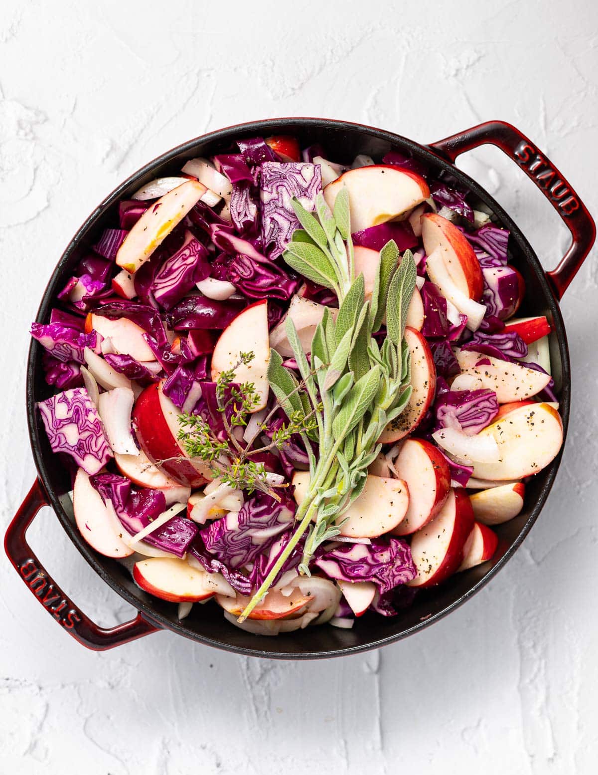 red cabbage, apples and herbs in a skillet