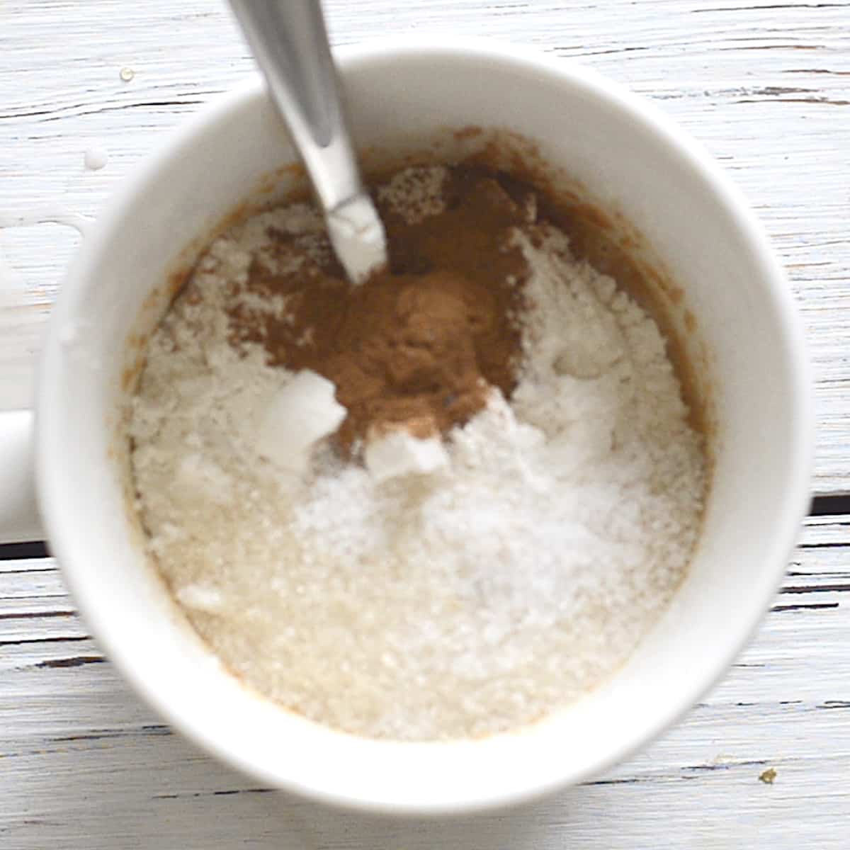 a mug with flour, cinnamon and sugar in it