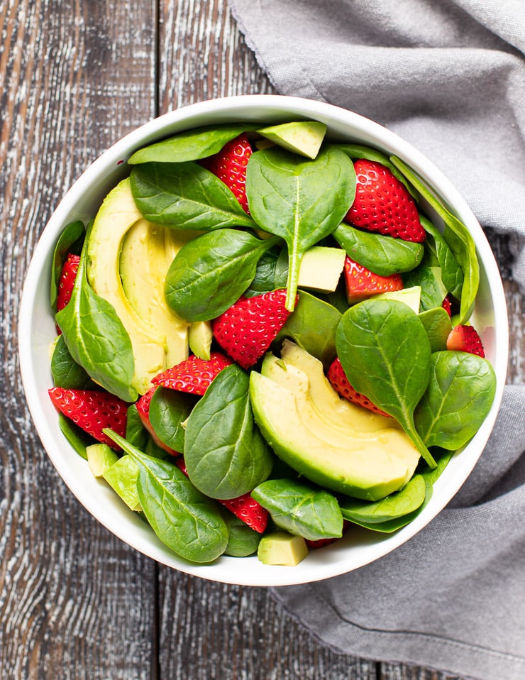 spinach strawberries and avocado in a bowl 