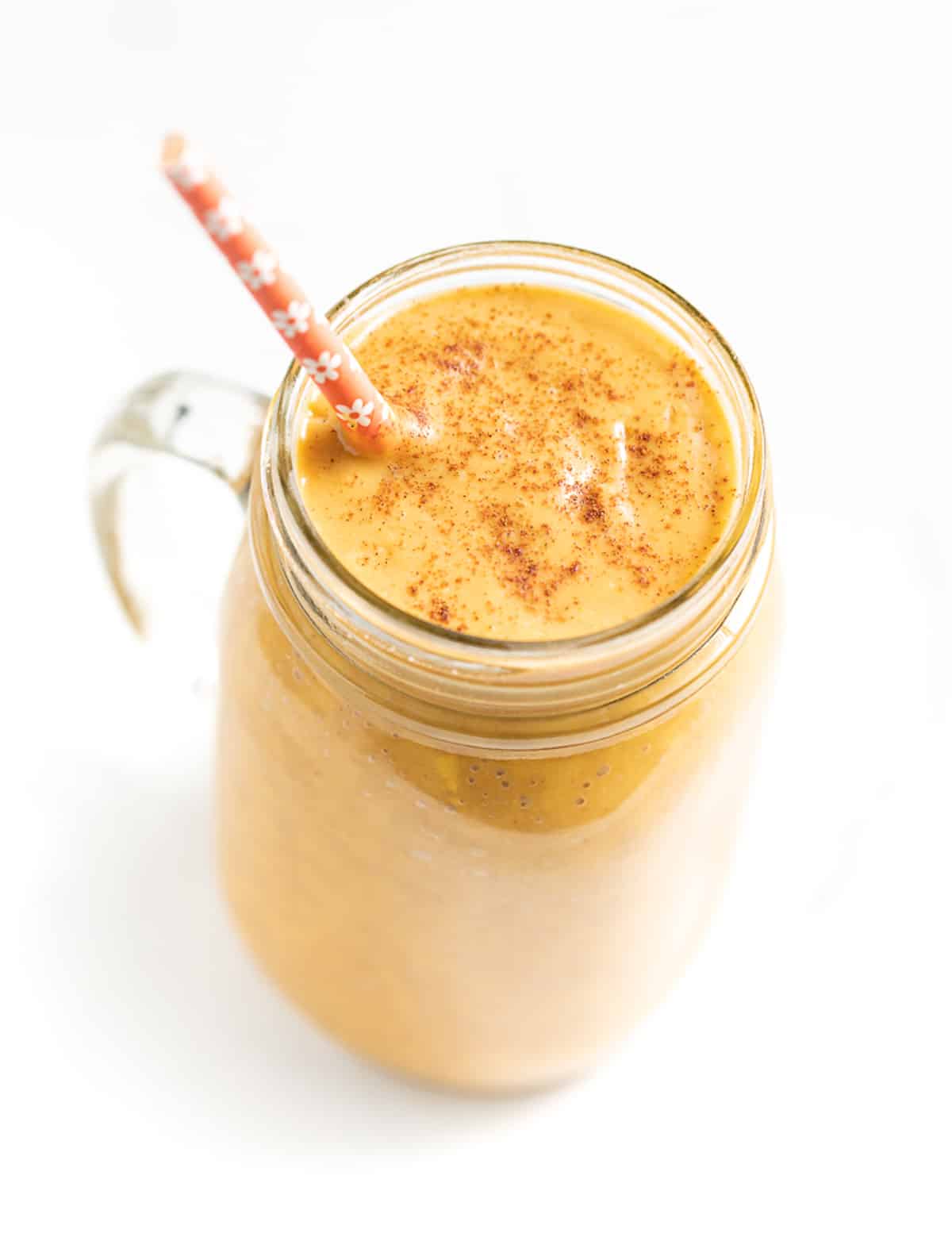 a sweet potato smoothie in a glass with an orange straw