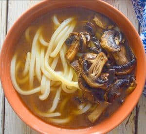 udon noodles, broth and mushrooms in a bowl