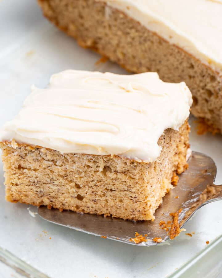 a slice of vegan banana cake being lifted out of a glass dish with a spatula