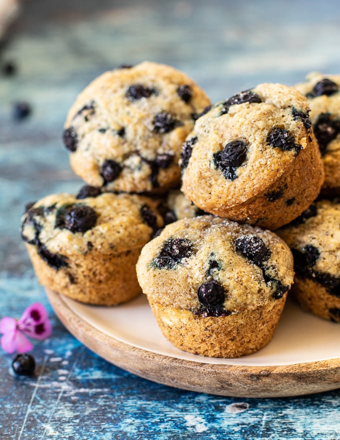 vegan blueberry muffins piled up on a plate