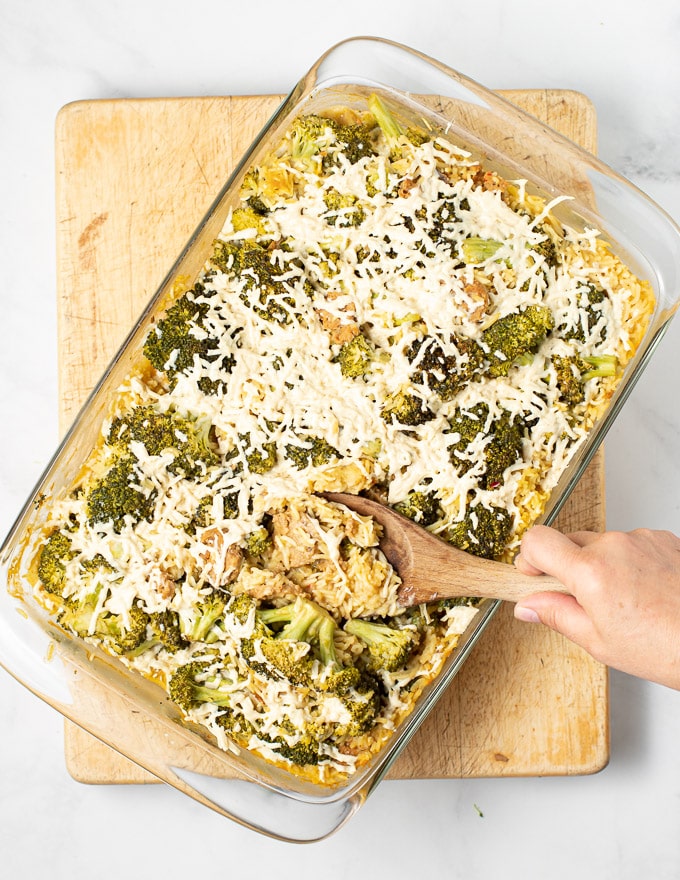 someone spooning out a big helping of vegan broccoli rice casserole