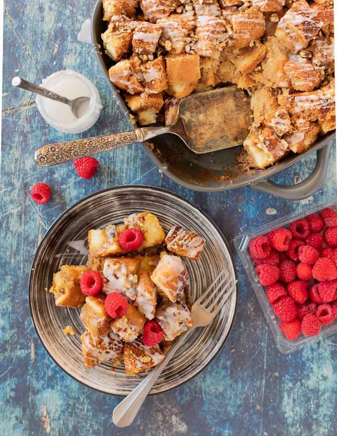 Vegan French Toast Casserole from above with a portion on a plate and a scattering of raspberries