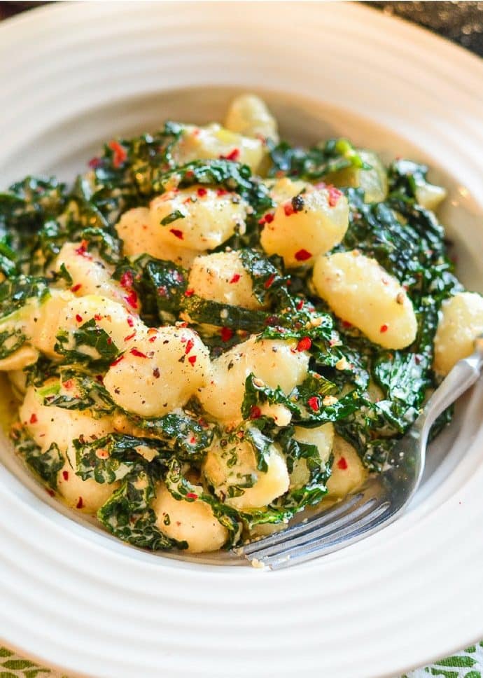 creamy vegan gnocchi with garlic and kale in a bowl