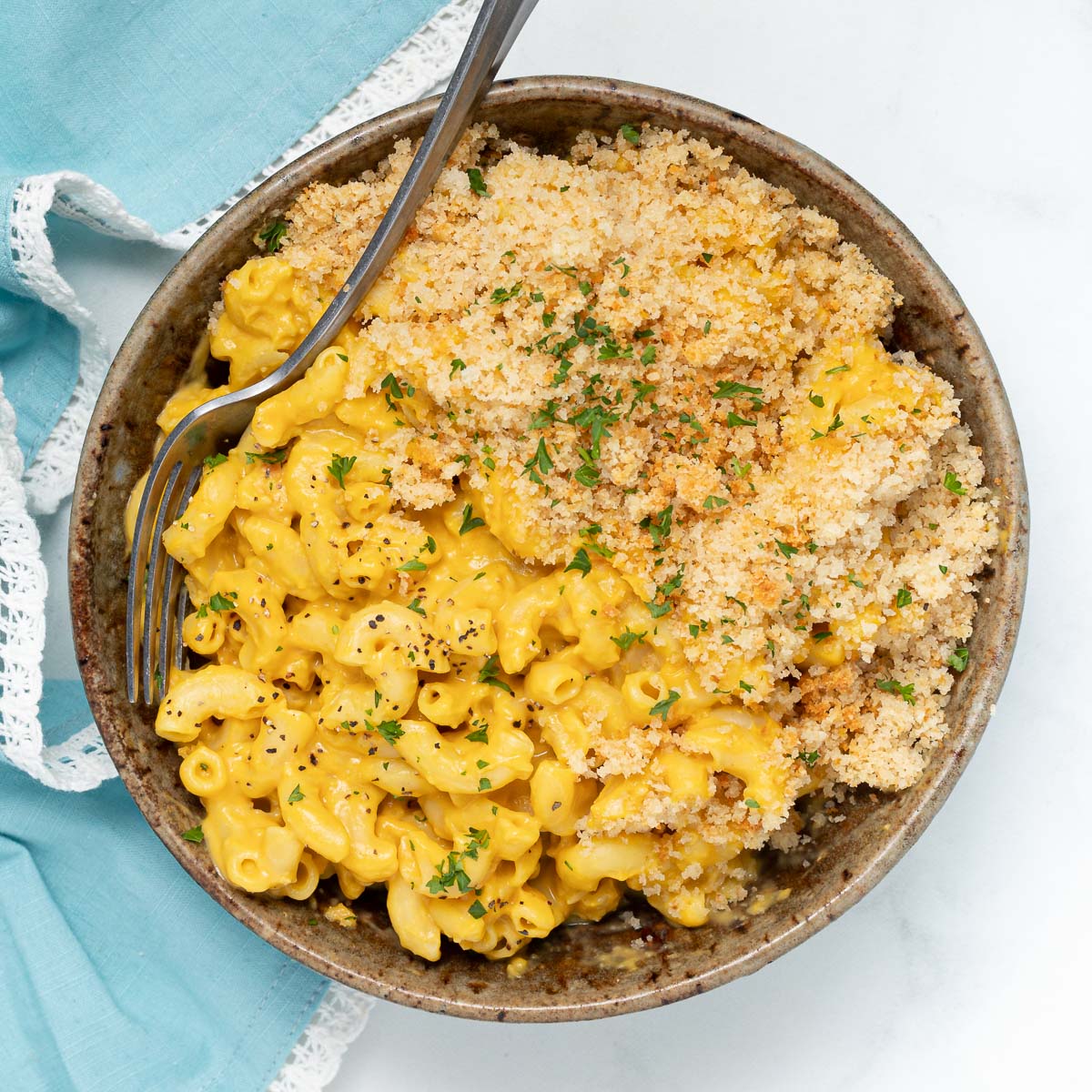 vegan mac and cheese in a bowl with a scattering of fresh parsley