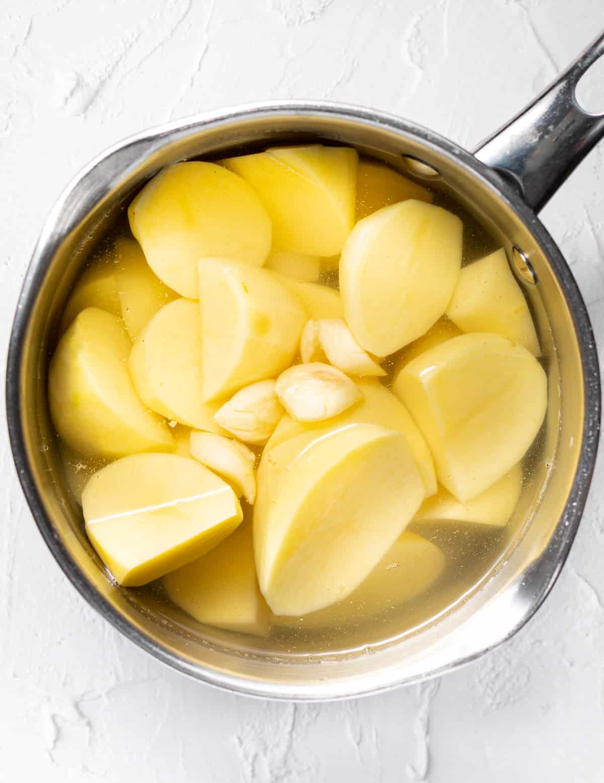 potatoes and garlic in a pan of water