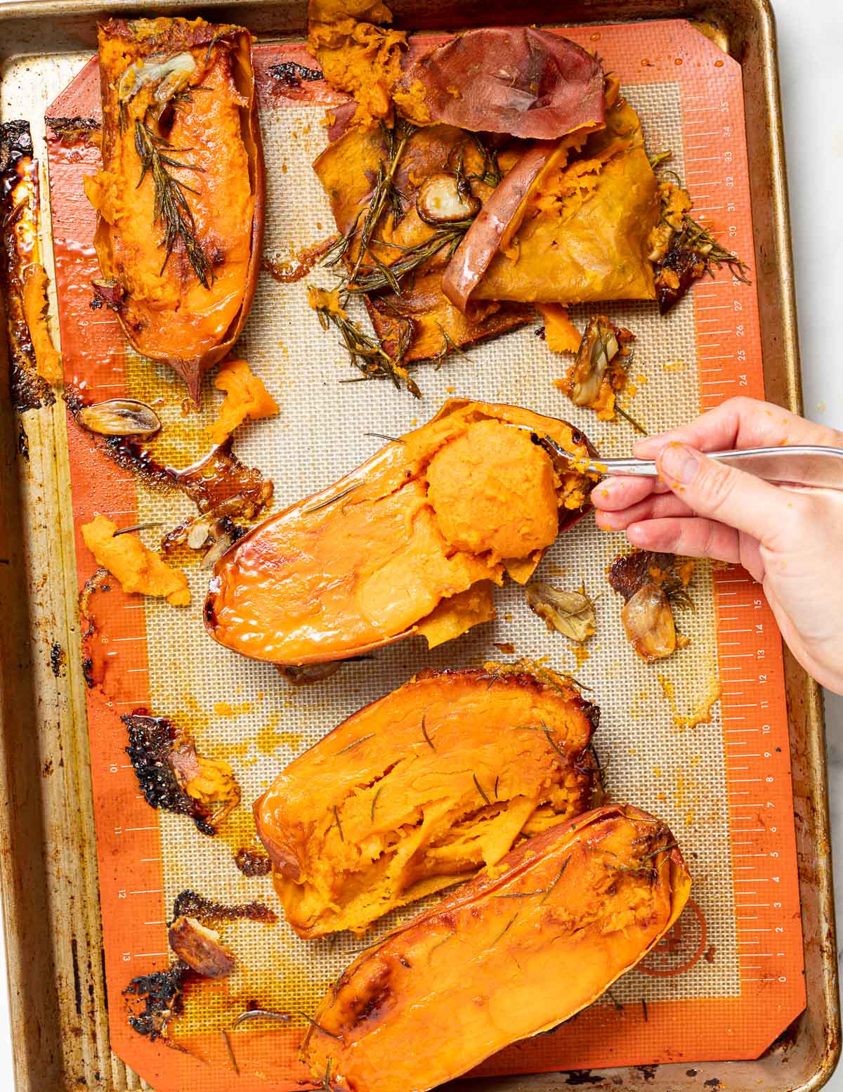 roasted sweet potatoes with garlic and rosemary on a baking tray
