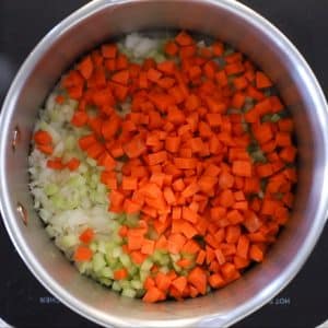 onion, celery and carrot sautéing in a pan - ready to make vegan potato soup