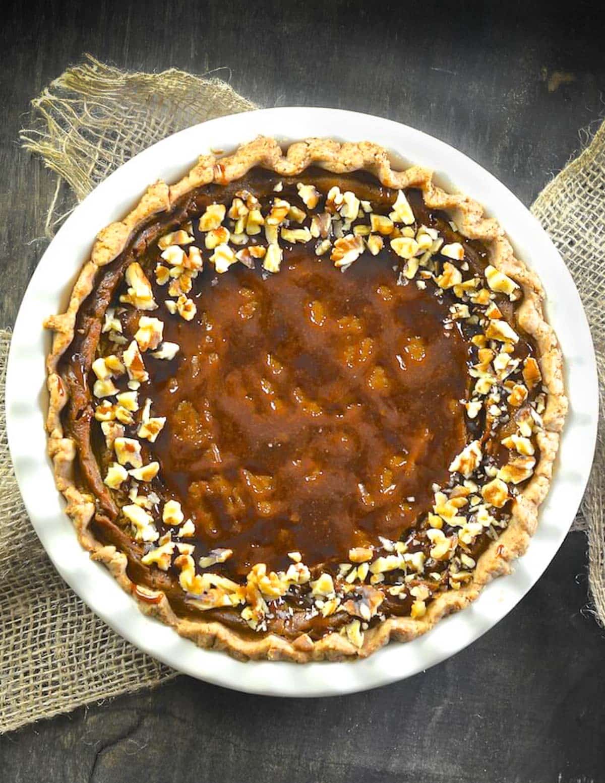 a vegan pumpkin pie topped with caramel and nuts
