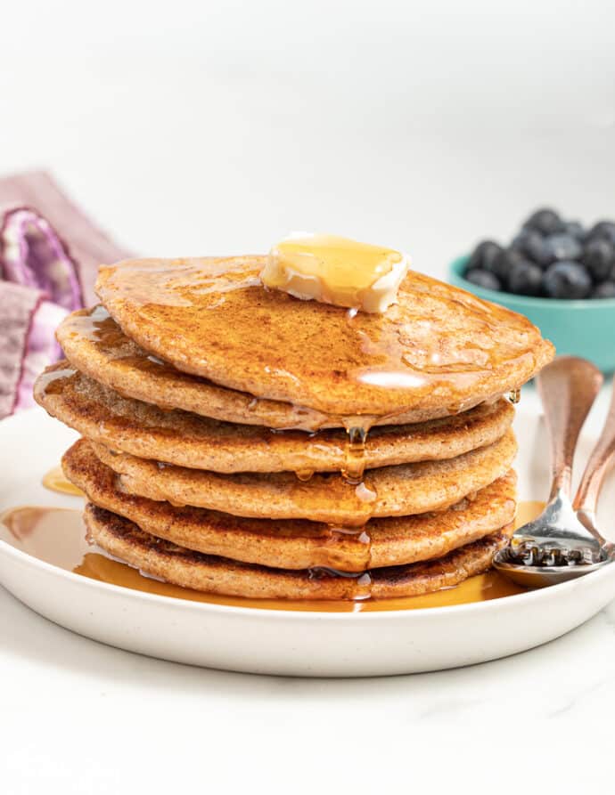 a stack of wholegrain egg-free pancakes with butter and maple syrup