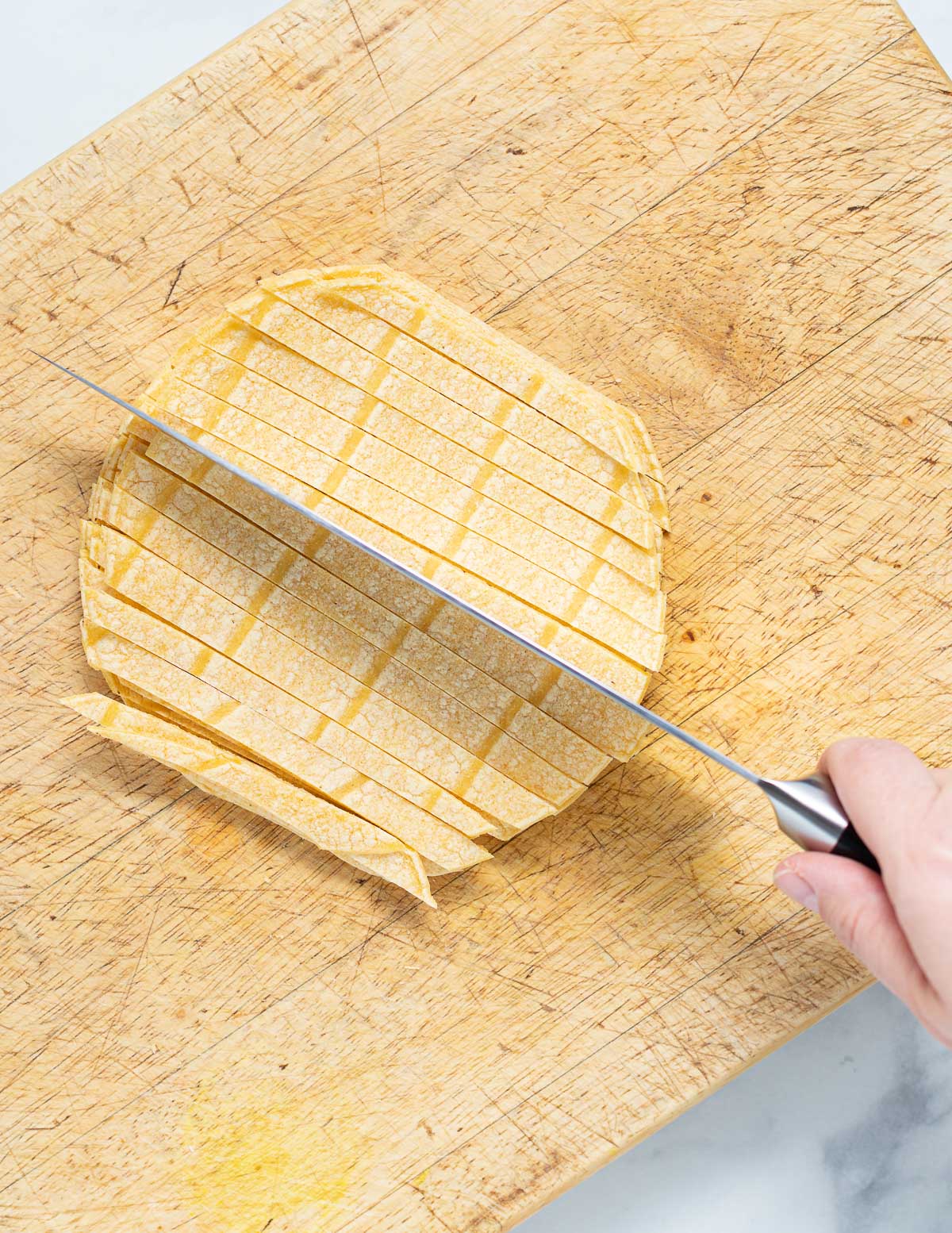 corn tortillas cut into strips on a board 