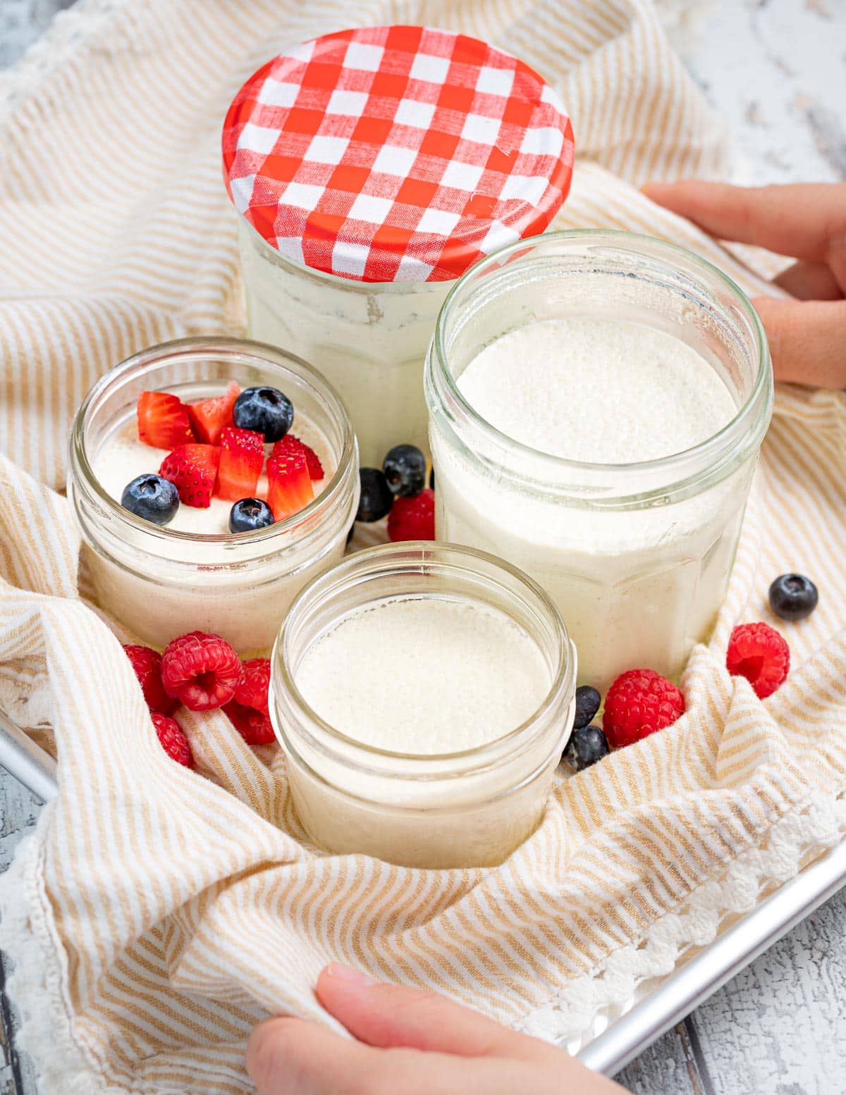 a tray with open jars of vegan yogurt on it