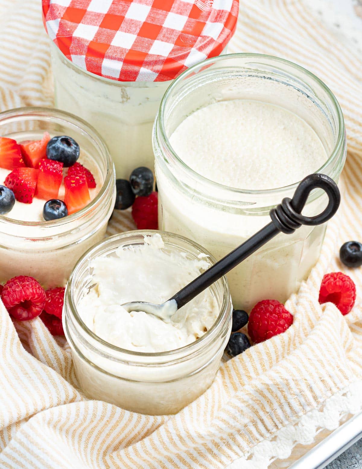 a jar of creamy vegan yogurt with a spoon in it